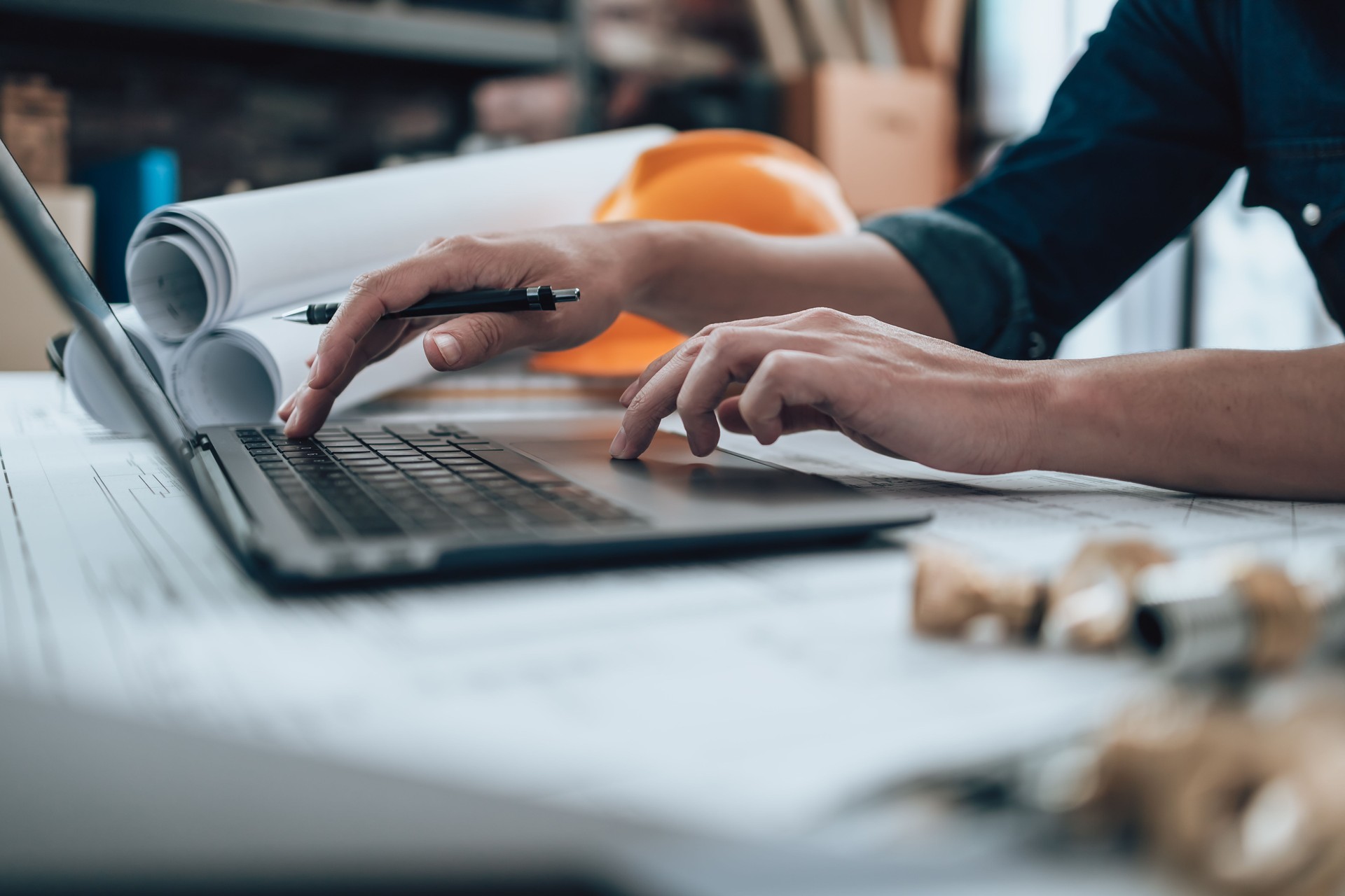Engineering working with drawings inspection on laptop  in the office and Calculator, triangle ruler, safety glasses, compass, vernier caliper on Blueprint. Engineer, Architect, Industry and factory concept.