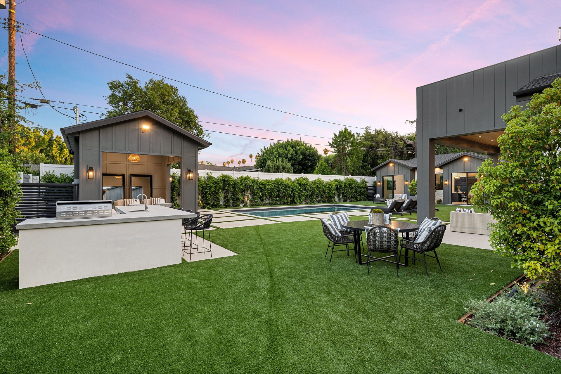 Modern backyard with pool and seating under evening sky
